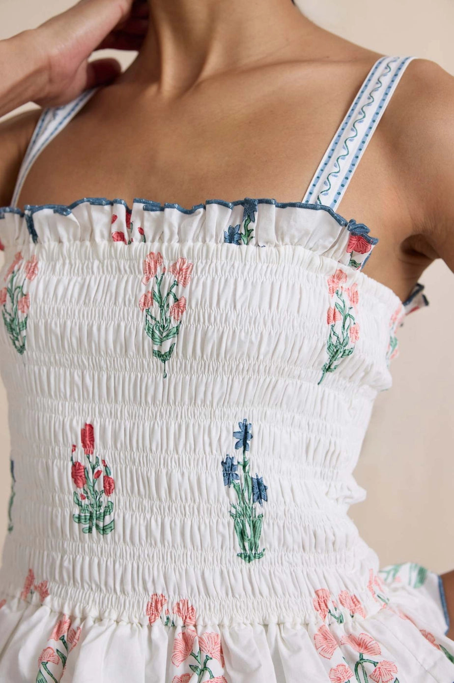 White dress with floral embroidery on a beige background